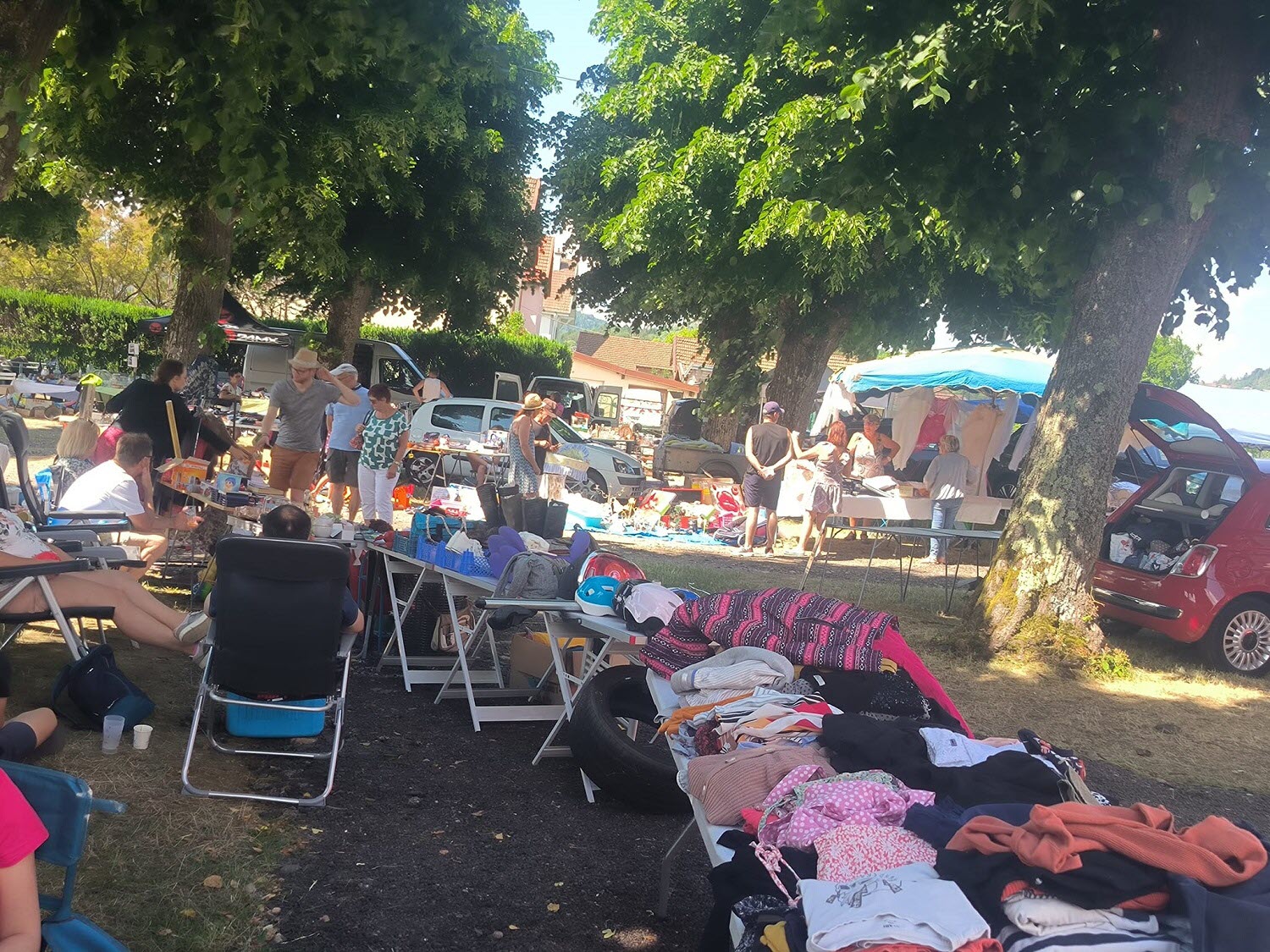 Stands de vide grenier installés sur une place de village dans les Vosges