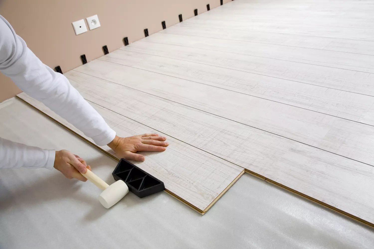 Lames de parquet stratifié clair posées dans un salon lumineux