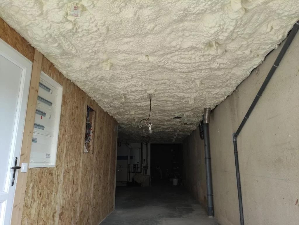 Application d'un enduit sur une zone de mousse expansive coupée en retrait sur un mur intérieur