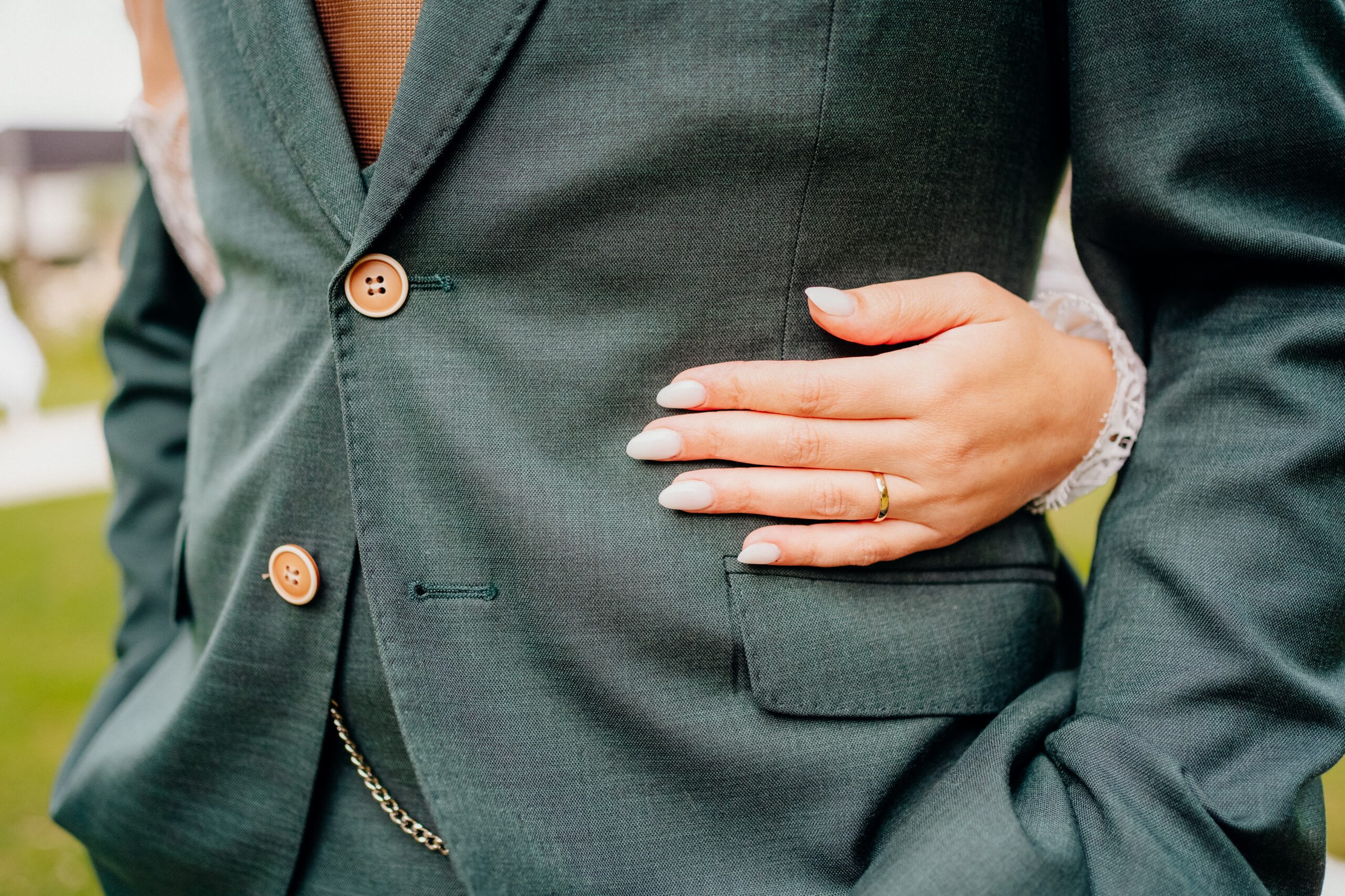 Essayage d'un costume pour mariage homme devant un miroir en boutique